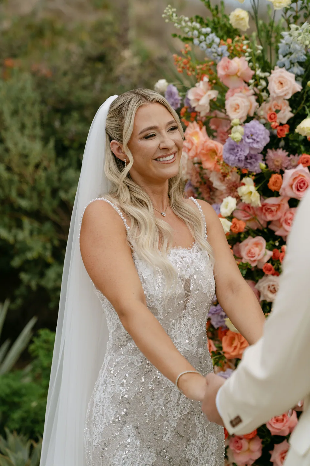 Bailey smiling with the flower arch behind her