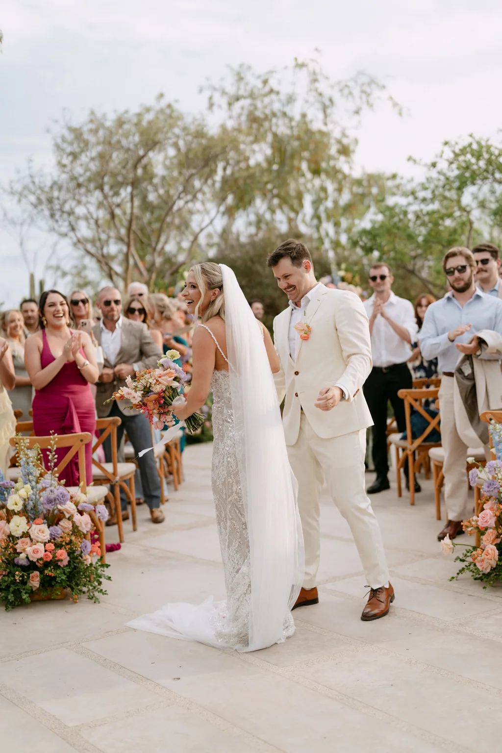 Bailey and Matthew walking back down the aisle, her veil in the air