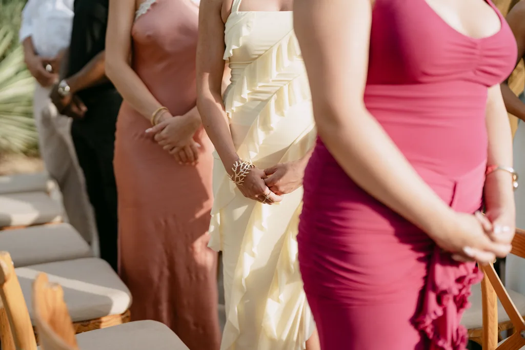 Guests in coral, butter and fuchsia waiting for the ceremony to start