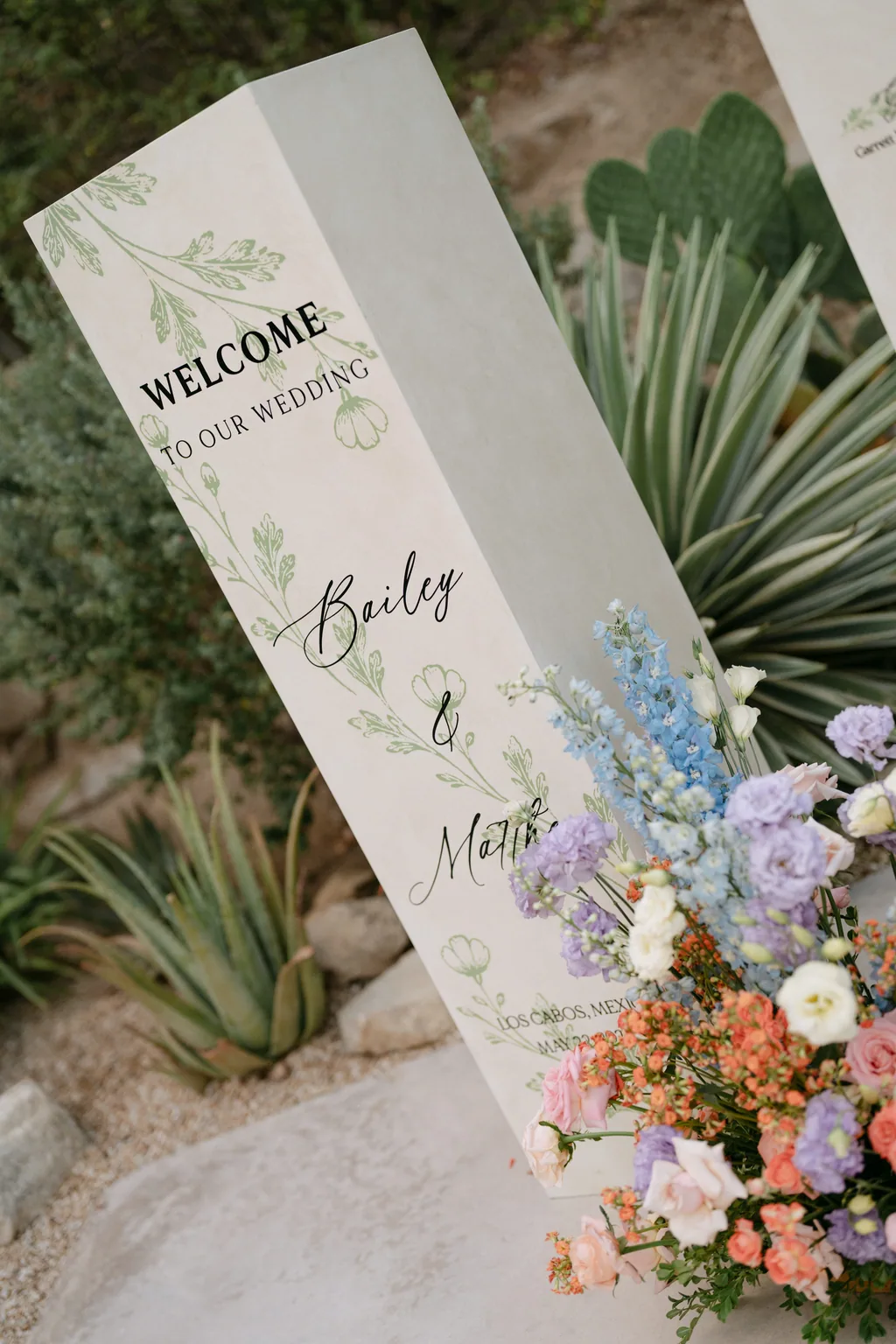 The welcome sign and its flowers at the entrance to the ceremony
