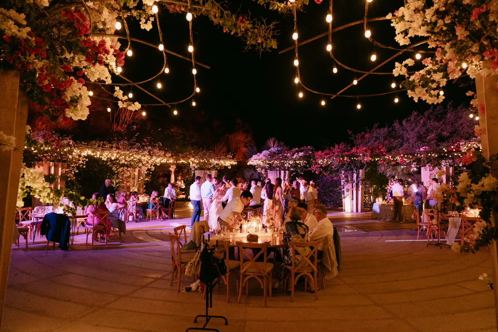 The reception at night under the bougainvillea and the string lights at Acre