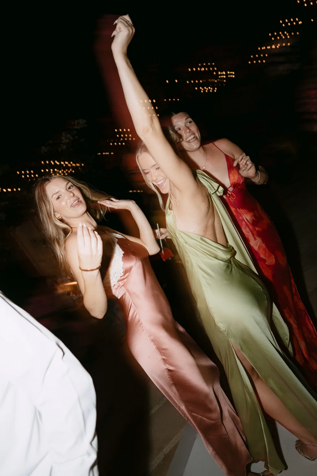 Hands in the air on the dance floor, sage and red silk