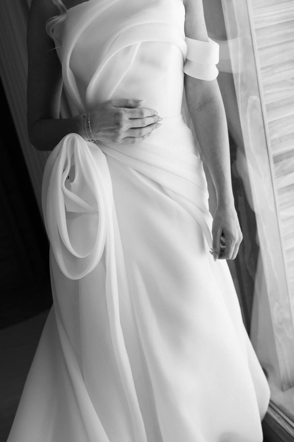 The bodice of the gown and a hand, in black and white