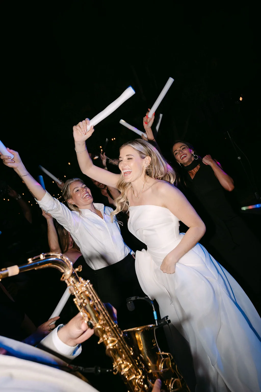 The saxophone player and the light sticks out on the dance floor