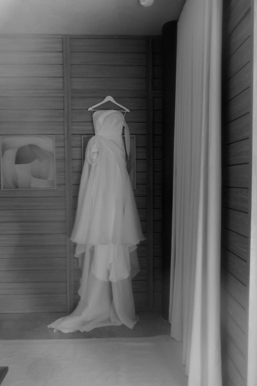 The wedding dress hanging in the room, in black and white