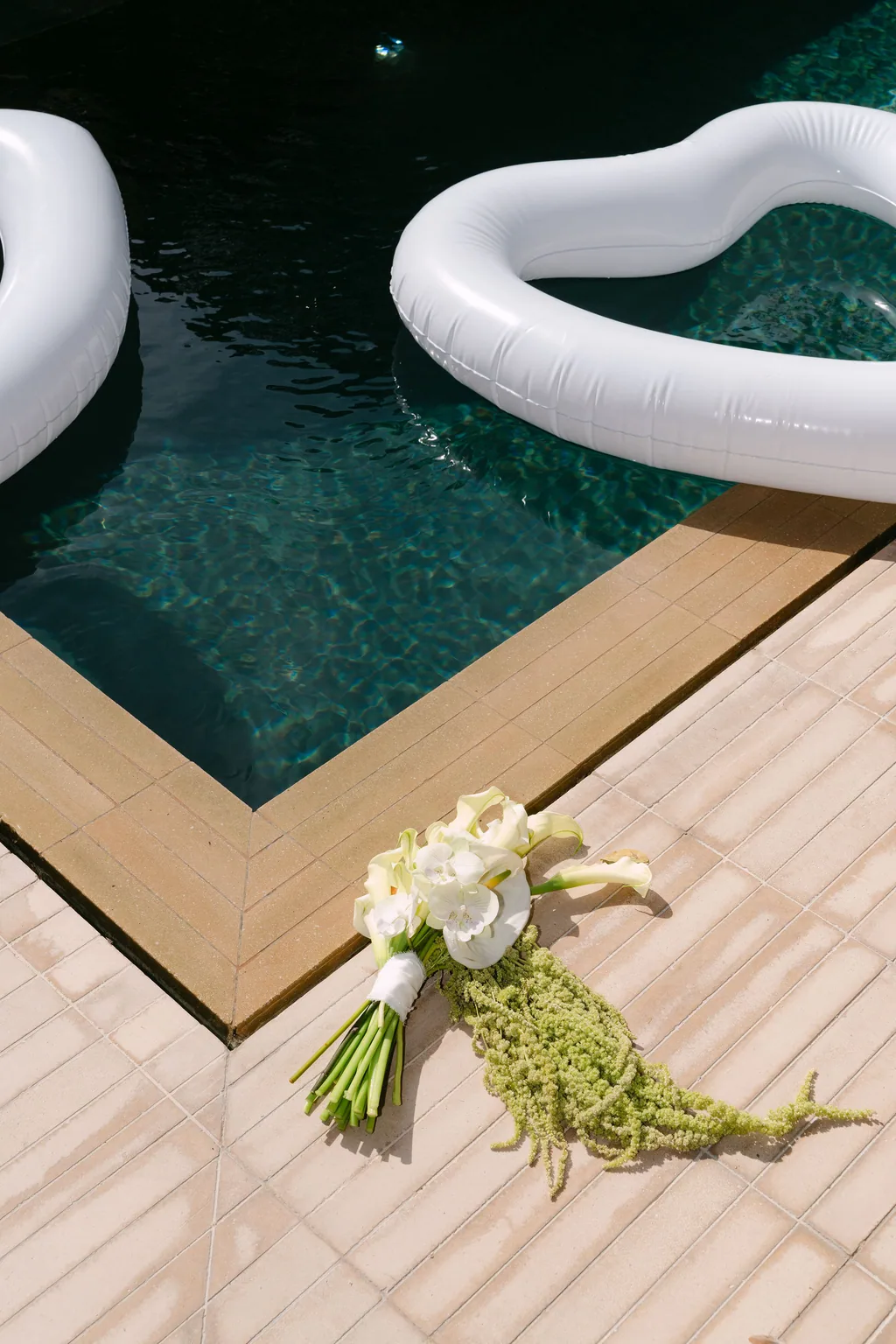 The bouquet resting on the deck at the edge of the pool