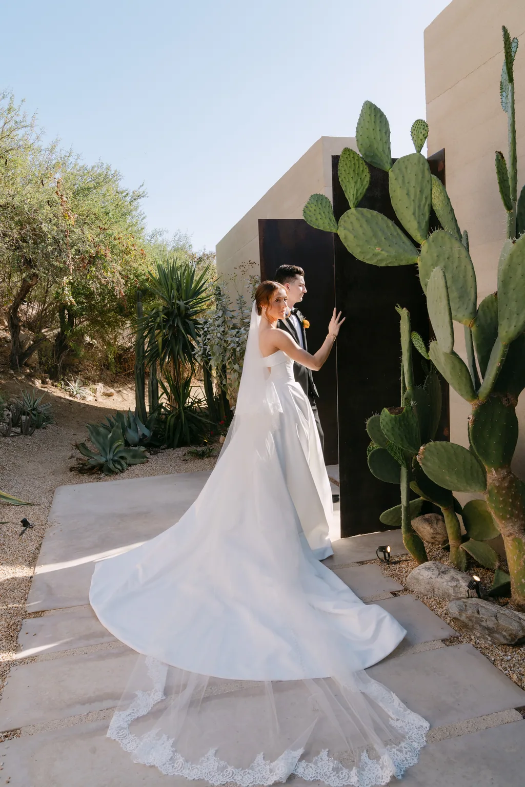 Her train swirling across the stone beside the cactus wall