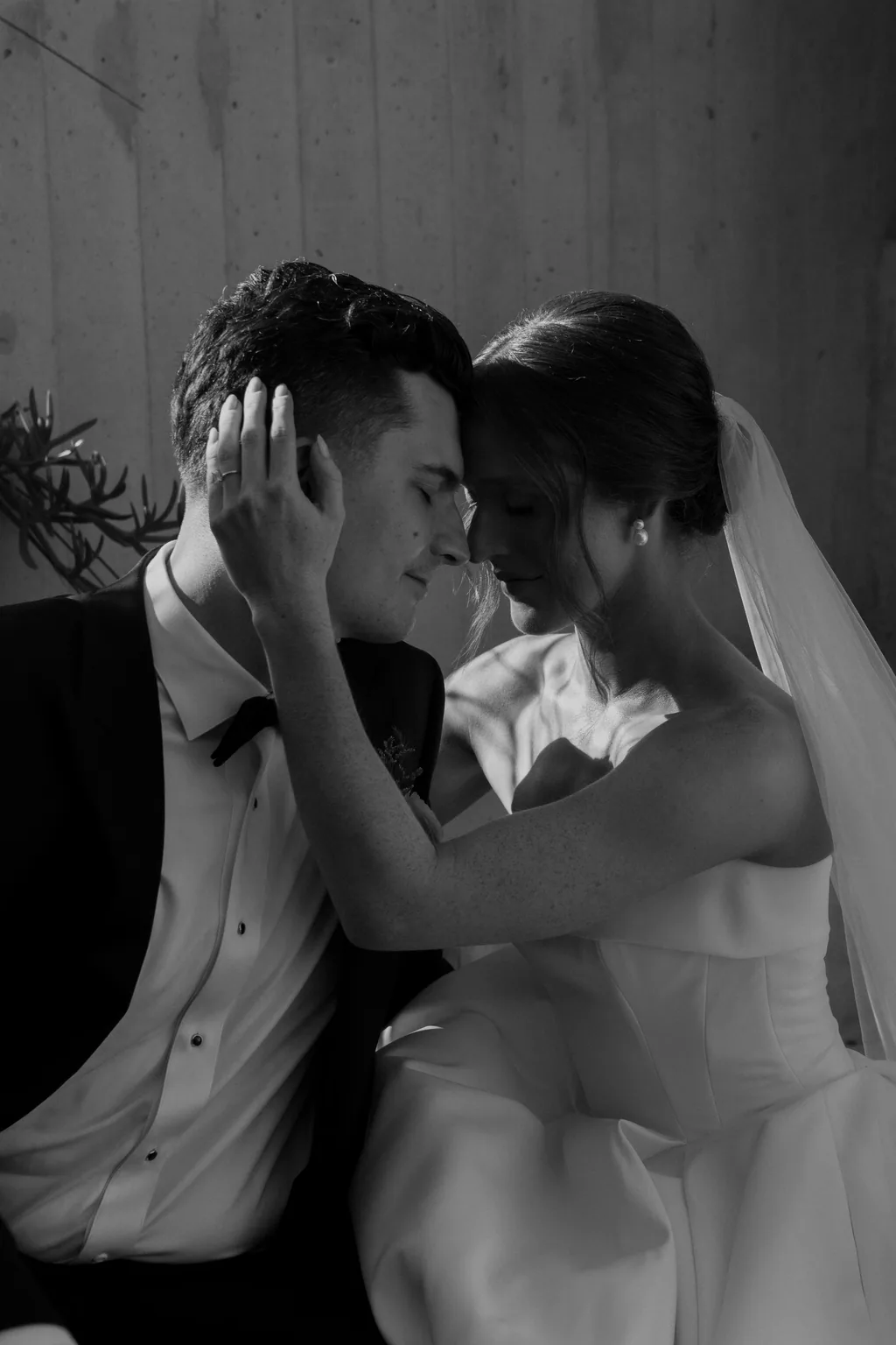 Lauren and Tevyn kissing, her hand on his face, in black and white