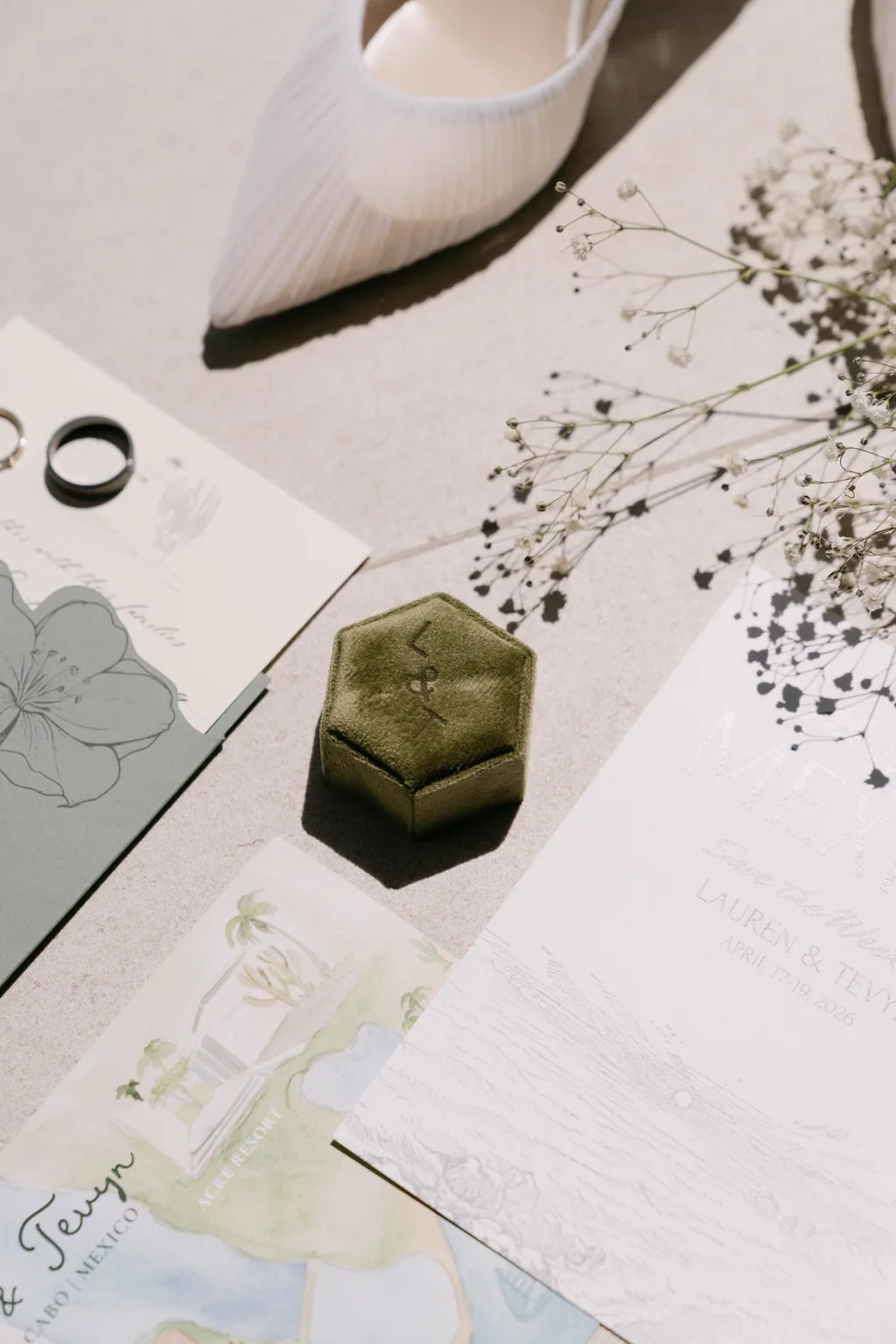 The bride's shoes, rings and invitation laid out before getting ready