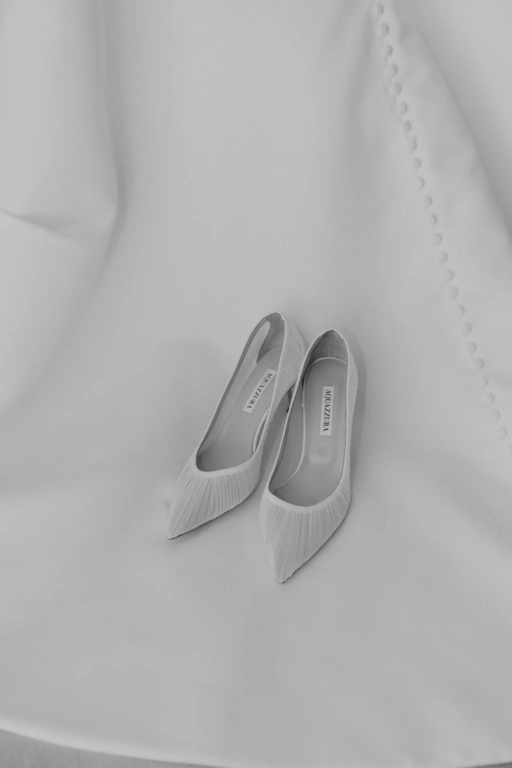 Her shoes resting on the skirt of the wedding dress