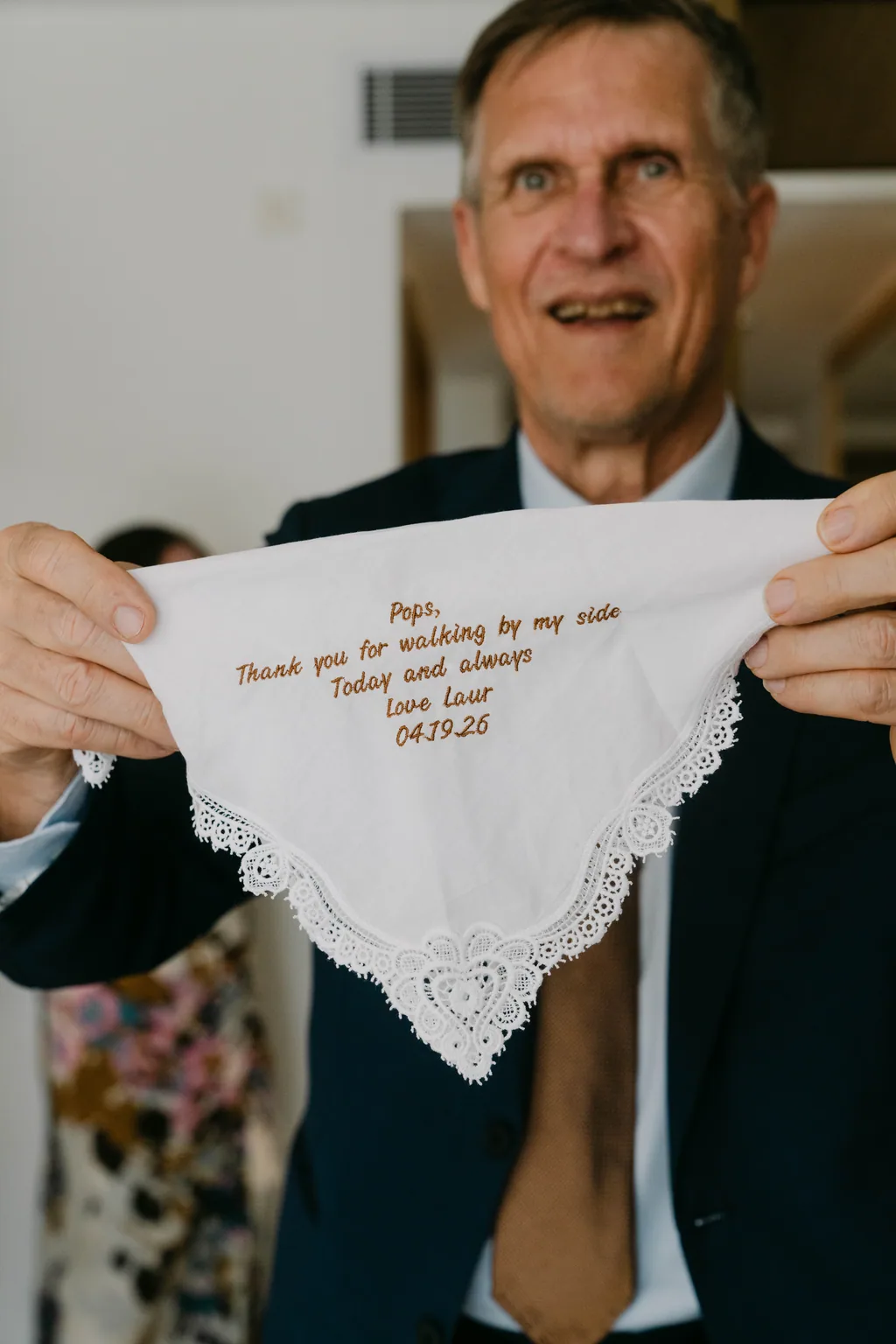 Her father holding the handkerchief she had embroidered for him