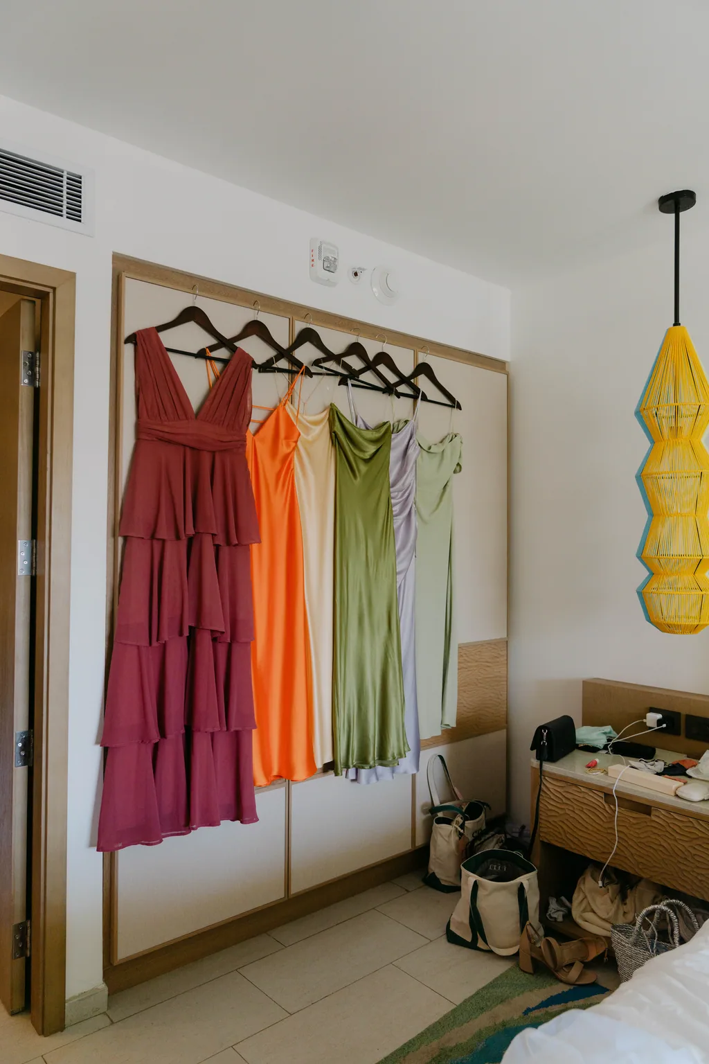 The bridesmaids dresses hanging together in the room