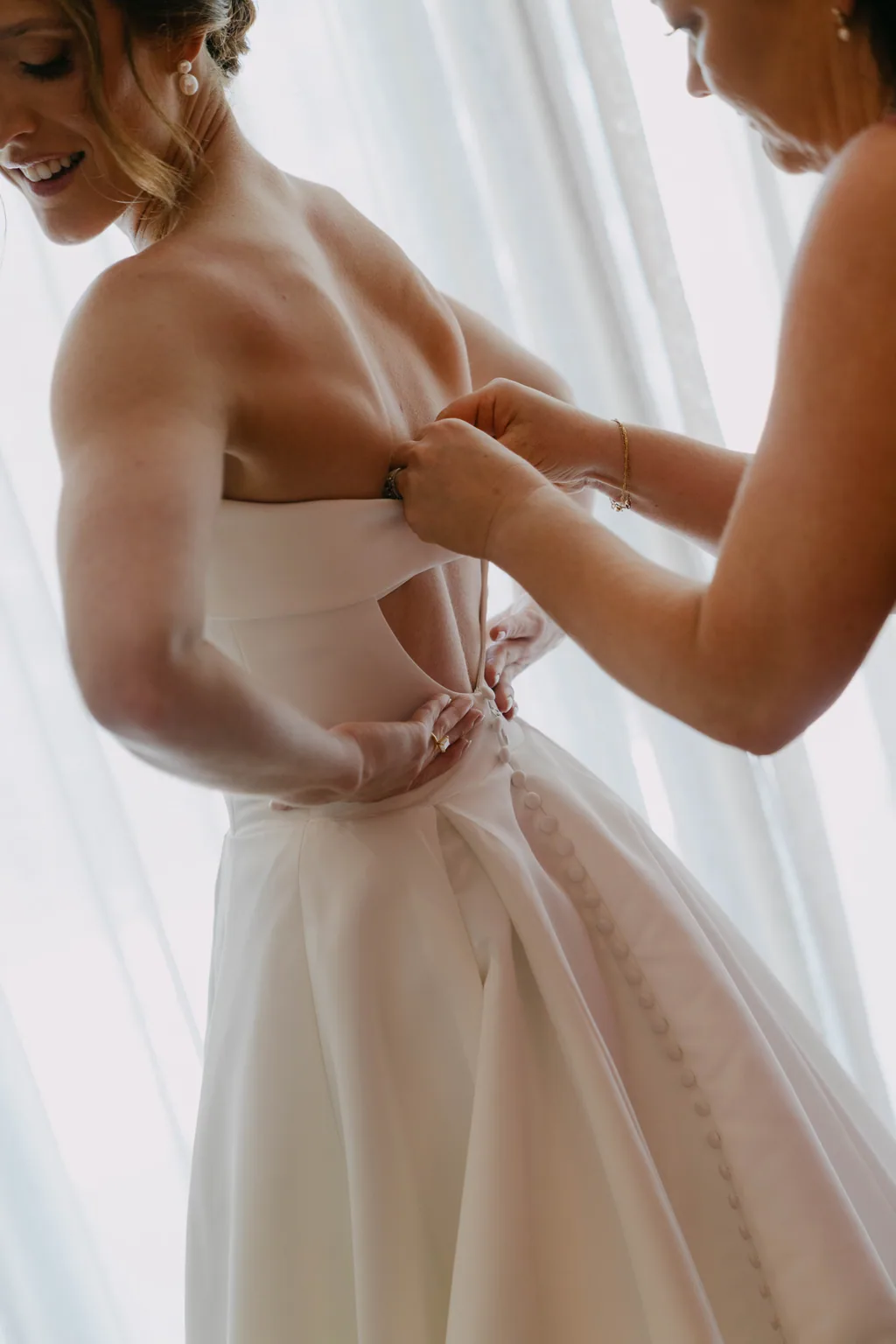 Buttoning the back of the dress against the window