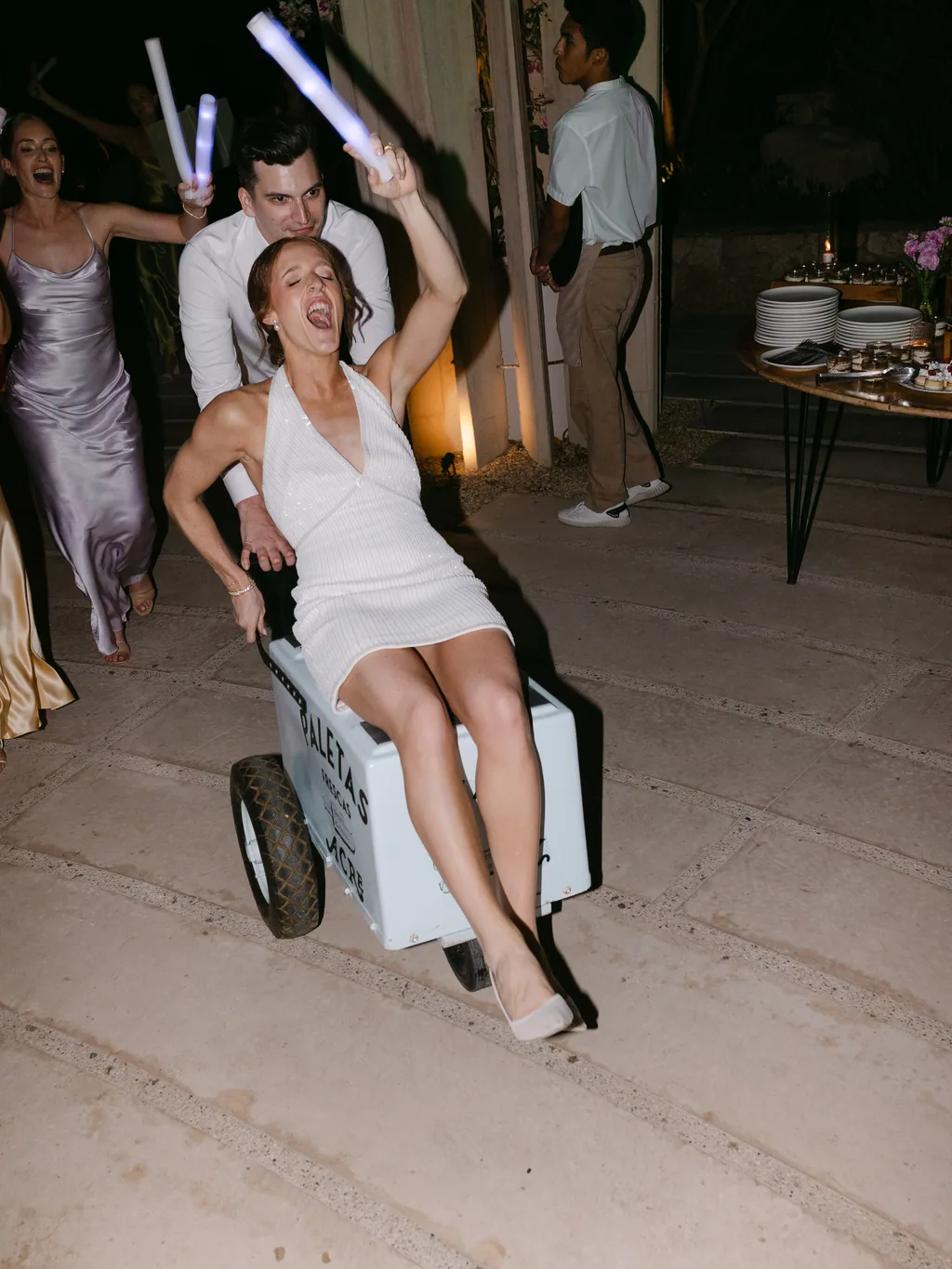 Lauren being pushed around the dance floor in the paletas cart
