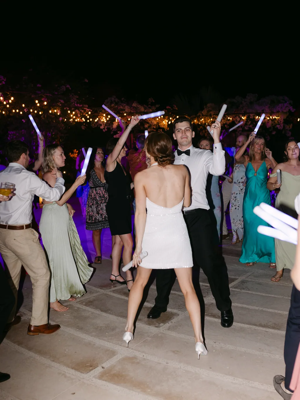 The dance floor under the string lights, full of glow sticks