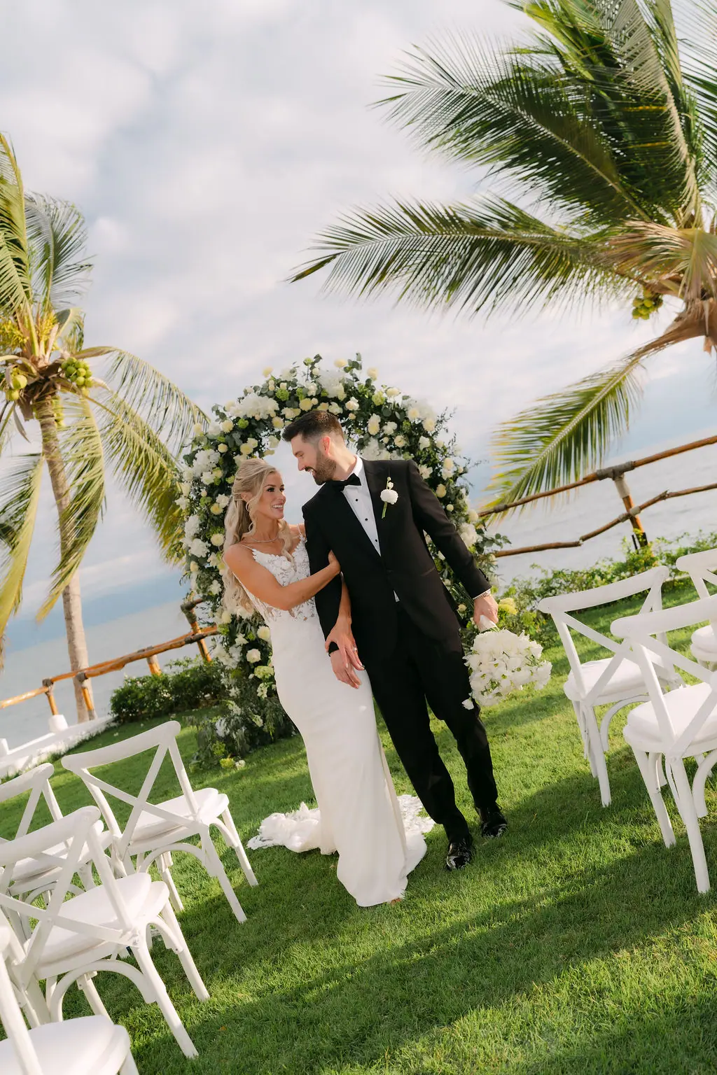 Macey and Travis under the floral arch